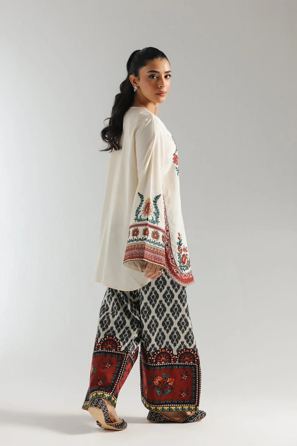Close-up of cream shirt with multicolor printed motifs and bell sleeve detailing