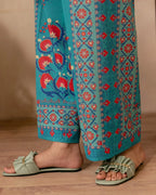 Close-up of digital floral and geometric print on teal blue fabric