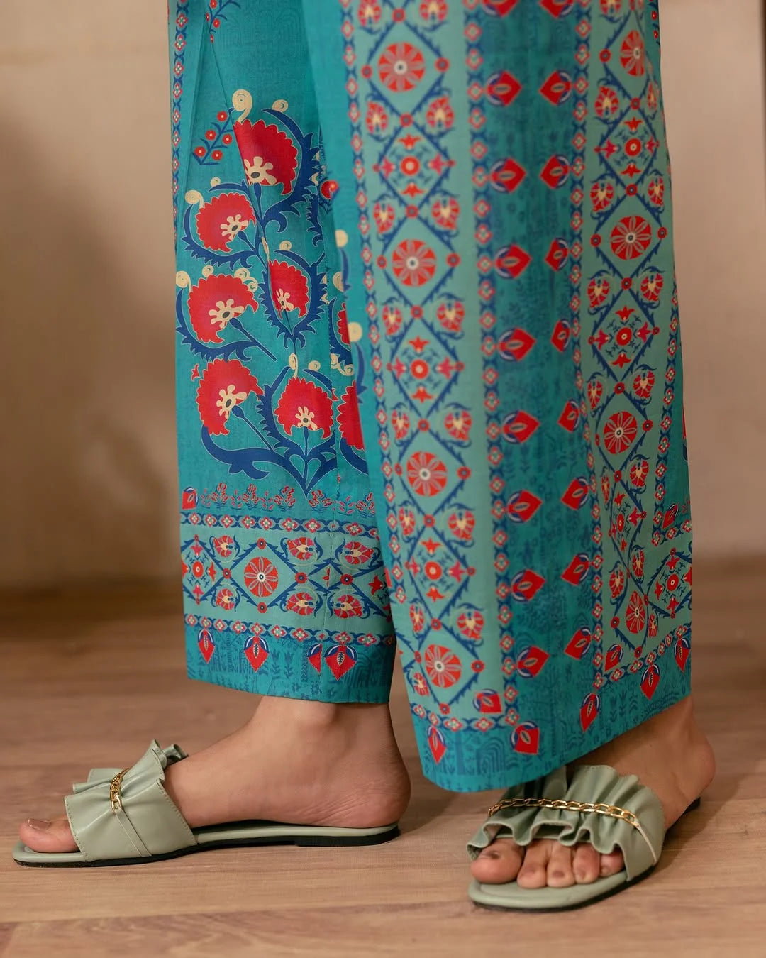 Close-up of digital floral and geometric print on teal blue fabric