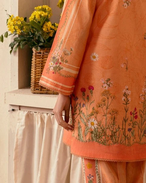 Close-up of floral digital design on peach orange shirt sleeve