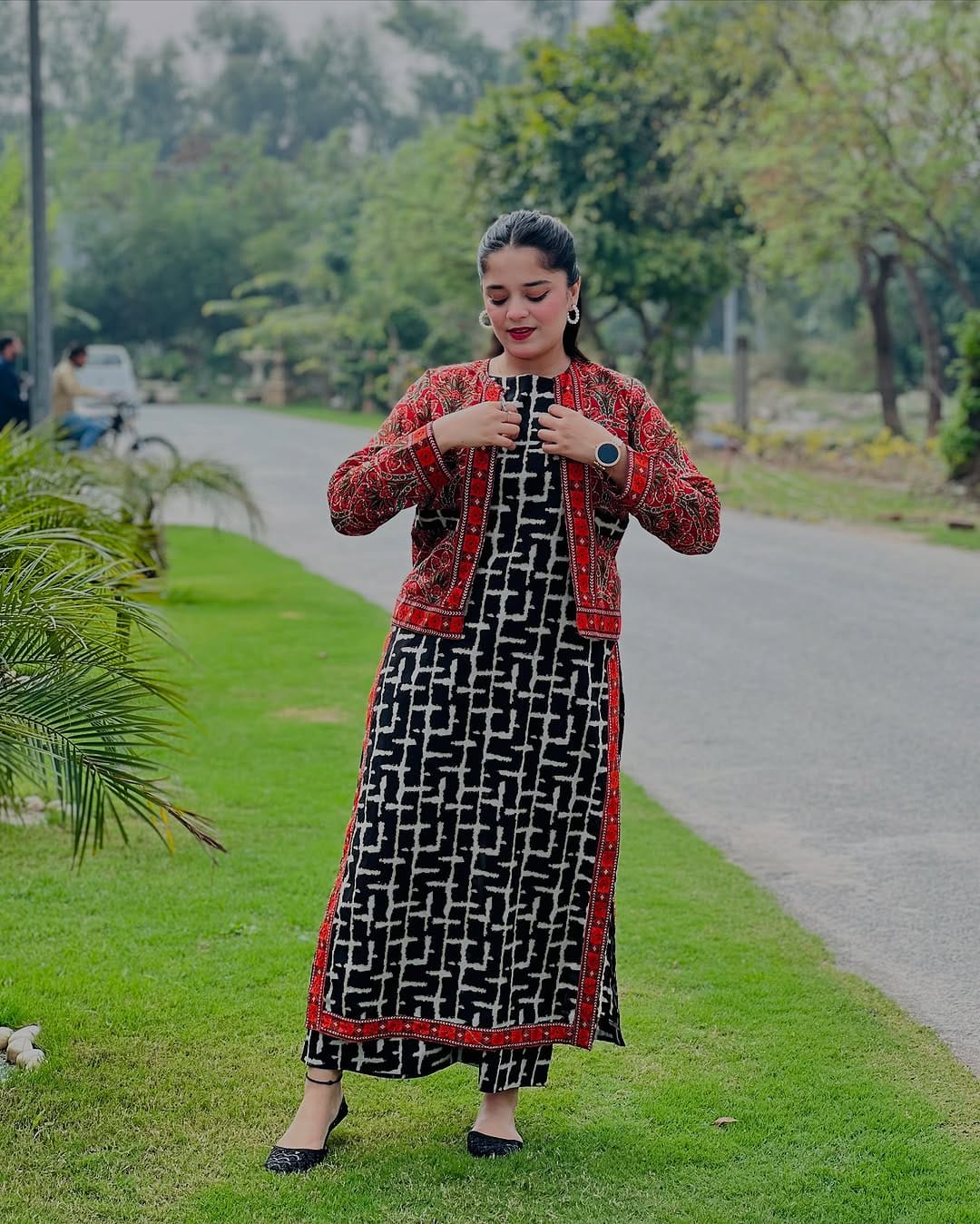 Close-up of red embroidered short jacket over printed black kurta