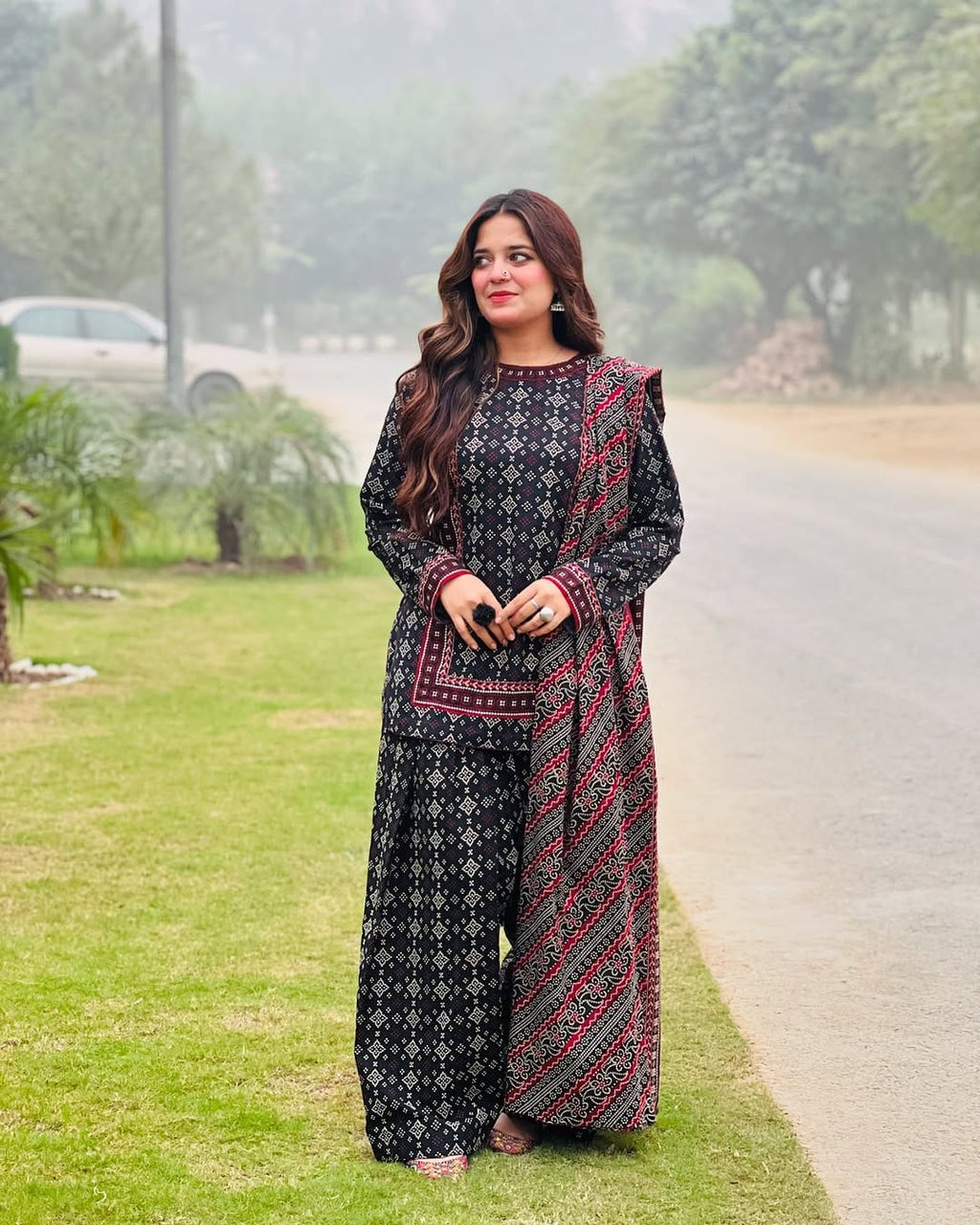 Model wearing black 3 piece digital printed lawn suit with red detailing