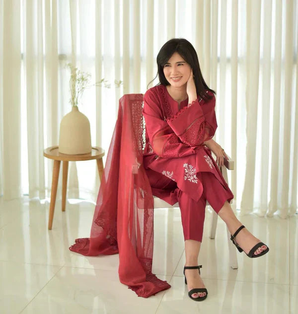 Close up of white thread embroidery on red shirt ZAMARANG